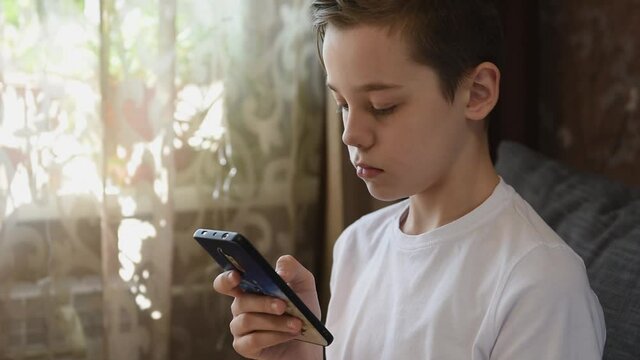 Young boy at home with smartphone