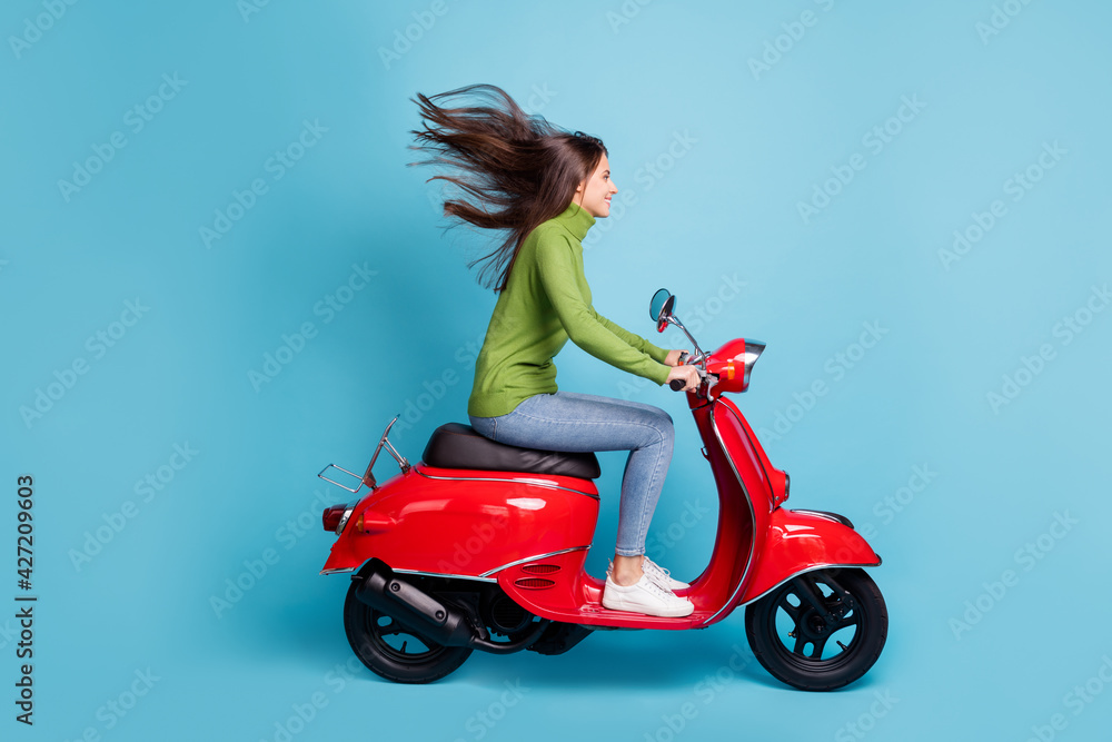 Sticker Full length side profile photo portrait of woman driving red scooter isolated on pastel blue colored background