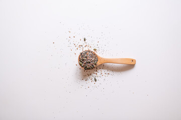 A wooden spoon with edible seeds on a white kitchen table