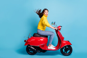 Fototapeta na wymiar Profile side view portrait of nice attractive amazed girl riding moped fast speed pout lips isolated over bright blue color background