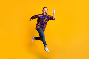 Fototapeta na wymiar Full length body size photo of man jumping high running fast on sale isolated on vibrant yellow color background