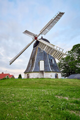 Fototapeta na wymiar antique windmill next to house in the city