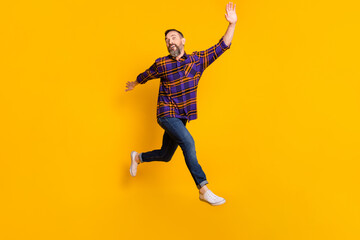 Fototapeta na wymiar Full length body size view of attractive funky cheerful guy jumping walking having fun fooling isolated over bright yellow color background