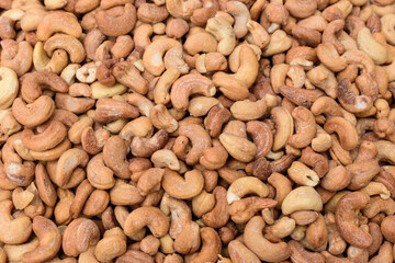 Roasted cashew nuts (Anacardium occidentale) for backdrop. Indian walnut, shelled and ready to eat. Top view.