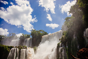 landscape of great Iguazu falls in Argentina. Blue sky, rocks and water.