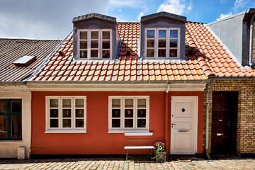 tiny cute red house with bench and flowers