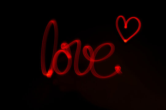 Schriftzug "love" mit rotem Licht geschrieben, ein wunderschöner Hintergrund für Ihr Grafikprojekt