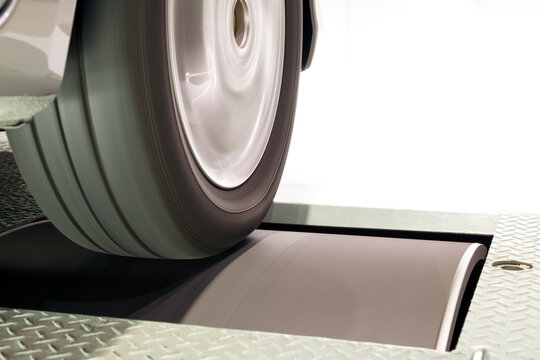 Close up of vehicle tire and rim rotation with blurry motion on roller Chassis dynamo
