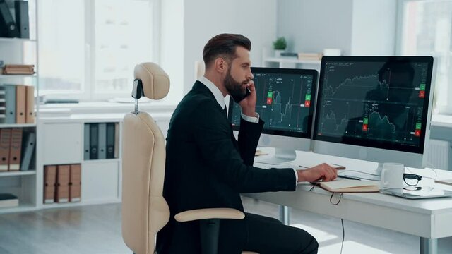 Concentrated young man in shirt and tie analyzing data on the stock market while working in the office