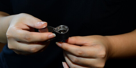 woman holding a magnifying glass looking at beautiful jewelry aquamarine