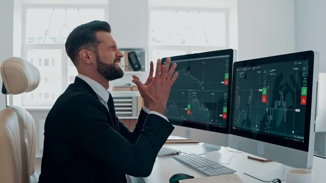 Frustrated young man in formalwear going through emotional stress while working in the office