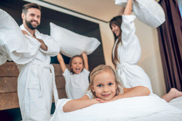 Obraz premium Family in white robes having a pillow fight