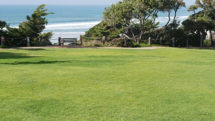 Fototapeta na wymiar Seagrove recreation beach park in Del Mar, California USA. Seaside garden with lawn in waterfront resort. Green grass and ocean coast view from above. Picturesque coastline vista point on steep hill.