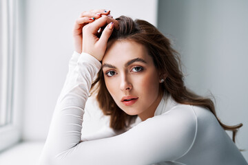 Close up portrait of sensual pretty young woman in white clothes