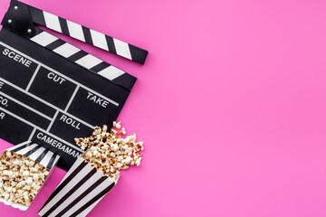 Film reel with popcorn and clapperboard. Cinema concept