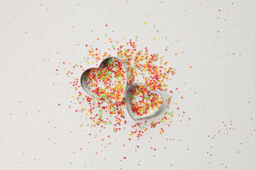 Heart shaped cookie molds on sugar sprinkle dots background, decoration for cake and bakery. Happy...