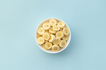 Many banana slices in white bowl. Top view