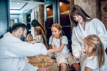 Cute family in bath robes brushing teeth together