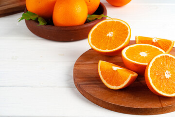 Cut oranges on wooden board on table