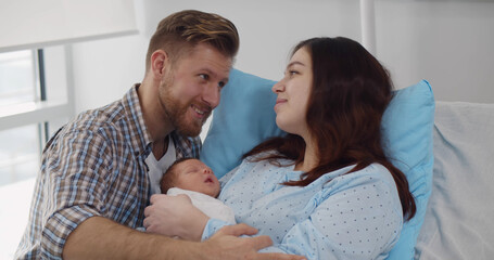 Happy mother and father with newborn baby at hospital