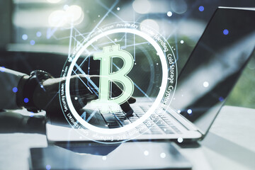 Creative Bitcoin concept with hands typing on laptop on background. Multiexposure