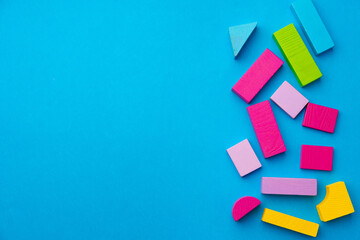 Multicolored pieces of toy constructor on blue background