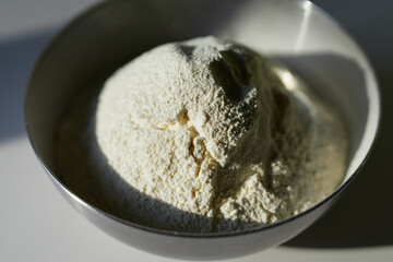 Making Easter pie or tasty cookie baking concept. Sifted four in a stainless steel bowl with hard sunset light. Vertical image. High quality photo