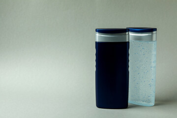 Bottles of shower gel on light gray background