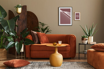 Domestic interior of living room with design sofa, mock up poster frames, a lot of plants, coffee...