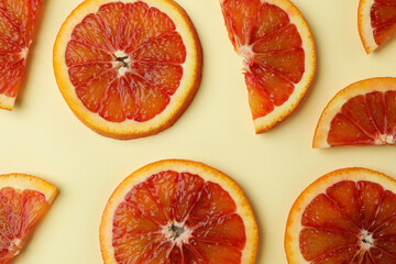 Naklejka na ściany i meble Red orange slices on beige background, close up