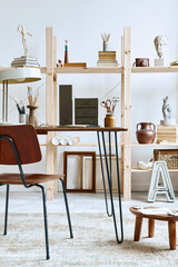 Unique artist workspace interior with stylish desk, wooden easel, bookcase, artworks, painting accessories, decoration and elegant personal stuff. Modern work room for artist. Template.