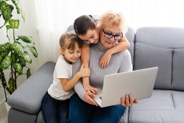 Grandmother with granddaughters use a computer