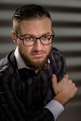 Portrait of young handsome smart man correcting glasses