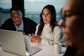 Confident young female manager working with diverse coworkers team in office
