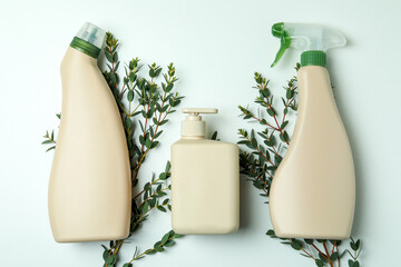 Blank detergent bottles and twigs on white background