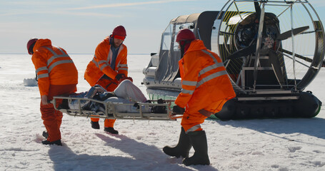 Lifesavers reanimating victim on stretchers in arctic on frozen ocean