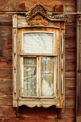 Close-up of wooden window in russian country house with half-broken decorations