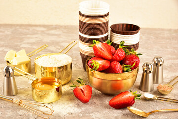Background baking flat lay with golden devices, strawberries and flour.