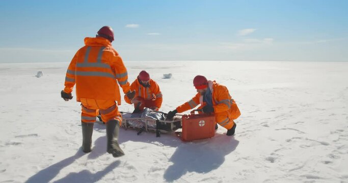 Lifeguards on hovercraft giving first aid to drown victim