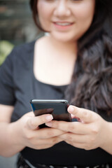 Close-up image of young woman using application on smartphone or texting friends