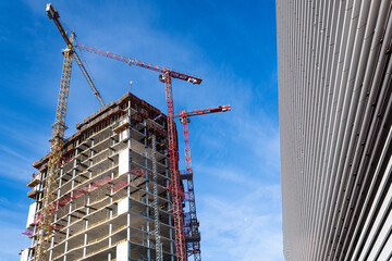 construction site in berlin with skyscraper, cranes an blue sky