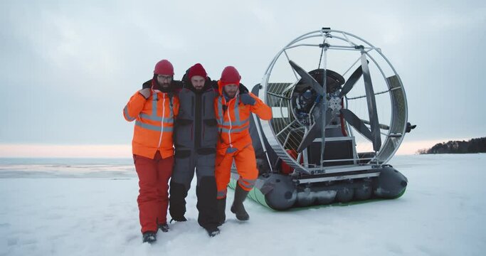 Lifeguard team saving and delivering injured fisherman to the shore in hovercraft