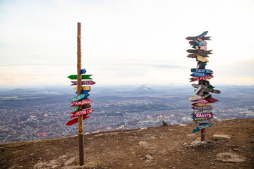 Obraz premium Poles with pointers on wooden plaques at the top of the mountain