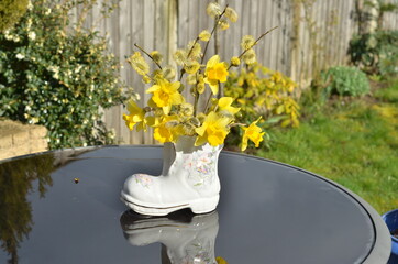 Bouquet of yellow flowers in a boot vase