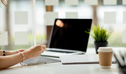 Close up of Businesswoman Hands Using digital tablet and laptop in office table.blank screen	
