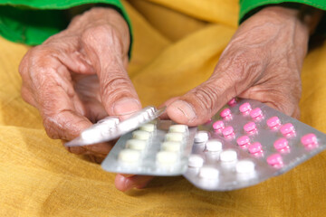 Close up of senior women hand holding blister packs .