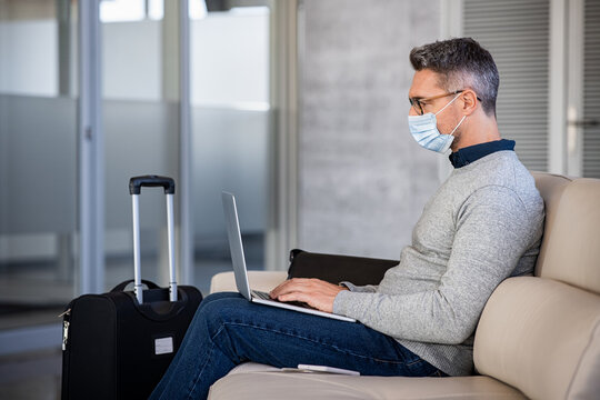 Mature Business Man Wearing Mask While Commuting And Using Laptop