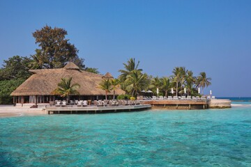 Beautiful View of Thatched Bar and Laccadive Sea in Maldivian Resort. Blue Sky and Turquoise Water in Maldives.