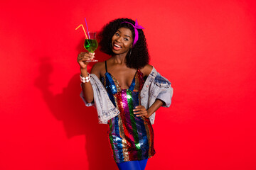 Photo of cheerful lady hold cocktail look camera wear dress jacket headband isolated red color background