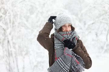 Fototapeta na wymiar Happy attractive woman in warm clothes in winter snowy weather outdoors